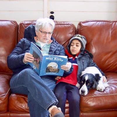 Child and adult enjoying reading The Adventures of MIss KItty - Finding a New Home book
